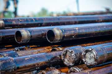 Oil Drill pipe. Rusty drill pipes were drilled in the well section. Downhole drilling rig. Laying the pipe on the deck. View of the shell of drill pipes laid in courtyard of the oil and gas warehouse