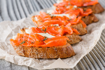 Bruschetta with smoked salmon and camembert on crumpled baking paper