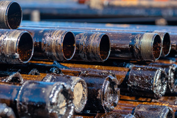 Oil Drill pipe. Rusty drill pipes were drilled in the well section. Downhole drilling rig. Laying the pipe on the deck. View of the shell of drill pipes laid in courtyard of the oil and gas warehouse