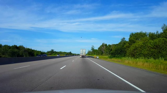 Drafting Large Truck on Highway During Summer Day.  Driver Point of View POV Slipstreaming by Following Vehicle on Interstate or Freeway or Expressway or Motorway or Turnpike.