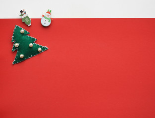 Christmas clothespins in the form of a snowman and mittens, a christmas tree made of felt on a red and white background, copy space