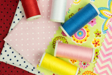 reels of sewing thread on swatches of fabric