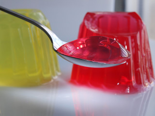spoon full of sweet jelly pudding strawberry flavor over white background