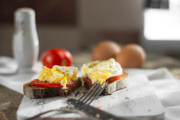 Poached egg on sourdough toast, with grilled tomatoes. A healthy, delicious breakfast or brunch