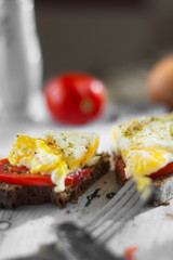 Poached egg on sourdough toast, with grilled tomatoes, mushrooms and salad leaves. A healthy, delicious breakfast or brunch.