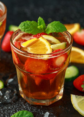 Refreshing Pimms Cocktail with Fruit and vegetables on rustic black table