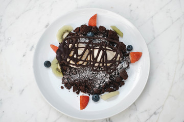 Chocolate crumble, Vanilla ice creams on chocolate cookies  crumbles with blueberries,  strawberries and kiwis