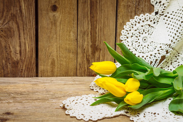 Bouquet of tulips on lace with wooden background - 283377307