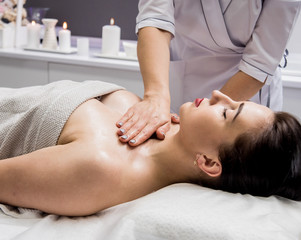 Fototapeta na wymiar Beautiful young woman enjoying massage in spa salon. Cosmetology