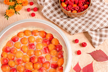 Homemade delicious sweet apricot pie served with raspberries on a table, top view