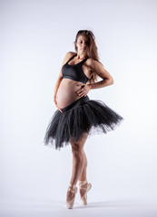 Naklejka premium Young beautiful pregnant ballerina with black dress.