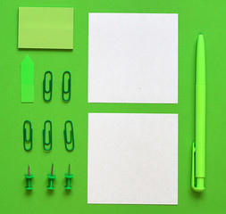 Pen, paper and stationery on a green background. In the green style. The concept of sustainable business. Flat lay, top view. Place for text