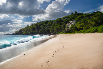 Exotic tropical beach Anse Takamaka on Seychelles islands, Mahe. Scenic view with impressive clouds on sunny day