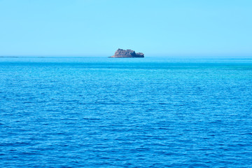Rocky island in the middle of the sea. Natural background texture. Copy space.