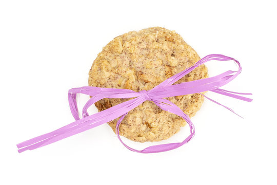 One Whole Oat Crumble Biscuit With Violet Ribbon Flatlay Isolated On White Background