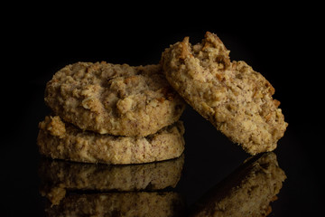 Group of three whole oat crumble biscuit isolated on black glass