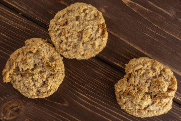 Group of three whole oat crumble biscuit flatlay on brown wood