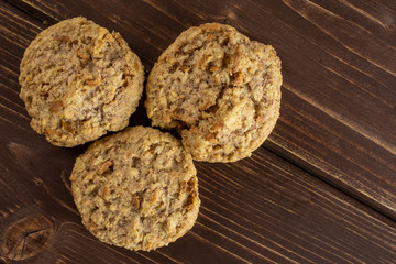 Group of three whole oat crumble biscuit flatlay on brown wood