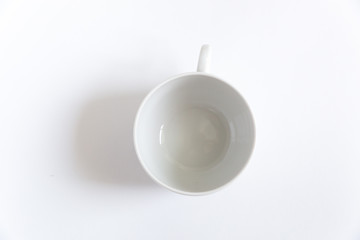 Empty white tea cup on a white background with a shadow. Top view. 
