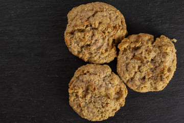 Group of three whole oat crumble biscuit flatlay on grey stone