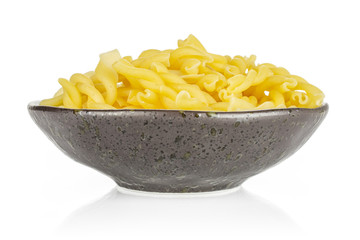 Lot of whole raw pasta gemelli on grey ceramic plate isolated on white background