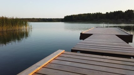 Wooden swimming pier on calm summer evening in Southern Finland.
