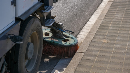 Sweeper truck industrial vehicle cleaning machine cleans urban road the streets of the city. Concept clean city. Street sweeper machine working.