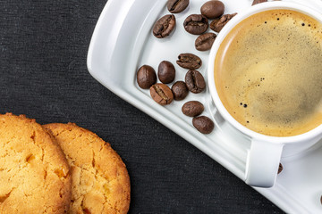 white cup of fresh hot coffee, grains of coffee and sugar cubes