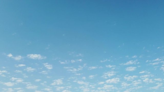 Beautiful and relaxing timelapse of mackerel sky with small, slow moving white clouds in blue and clean background