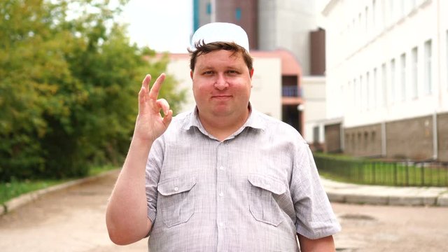 Young muslim man in city giving ok sign
