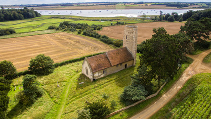 An aerial photo of Ramsholt church. A beautiful traditional church with a round tower located in the beautiful Suffolk countryside close to the River Deben - obrazy, fototapety, plakaty