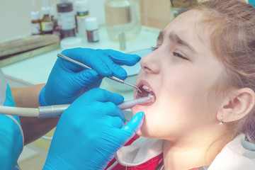 teenager girl at a reception in the office at the dentist sitting in a chair. Dentistry, pain, fear