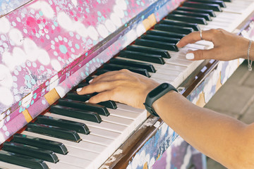 women's hands on the keys of the old piano