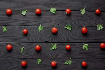 Fototapeta na wymiar pattern of fresh red cherry tomatoes and parsley leaves