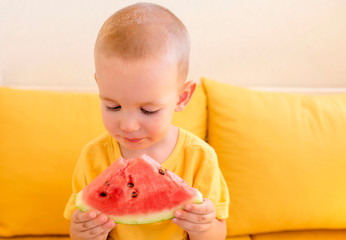 Adorable little boy enjoy eating watermelon outside