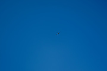 A light motor helicopter flies high in the sky