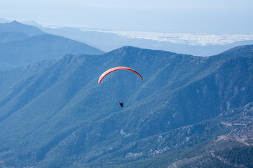 Paraglider flying over mountains