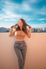 Woman, beige top, sunglasses, jeans