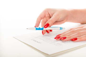 woman's hand with pen signing document.