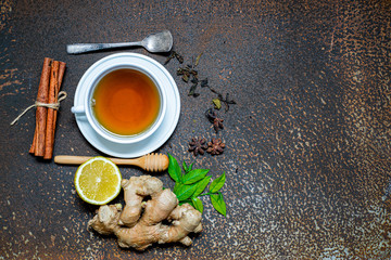 Closeup of cup of tea and herb on grunge dirty background