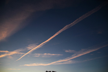Fototapeta na wymiar Evening sky with condensation trails