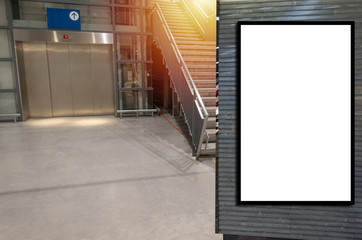 vertical blank showcase billboard or advertising light box for your text message or media content in front of elevator and stairs way in department store shopping mall, commercial, marketing concept