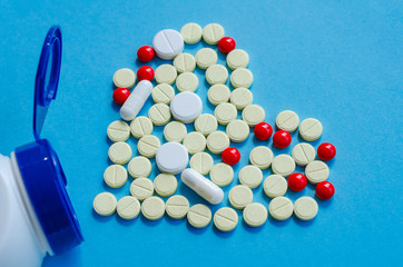 White heart pills on a colored background.