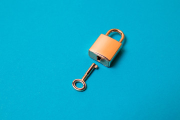Locked padlock and key on the blue background.