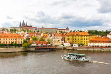 Prague cityscape with pleasure boat on river