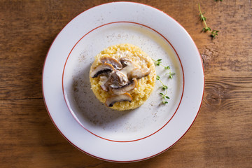 Healthy vegetarian dish: couscous with creamy mushroom sauce. Couscous with topping. View from above, top studio shot