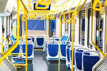 The interior of the electric bus is empty. For the passengers seat, handrails and overhead pens in...