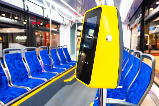 Public transport. Validator in the cabin of public transport. The bus is empty. Transportation of passengers inside the city. Yellow validator close-up. Non-cash payment for a trip in an electric bus.