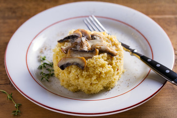 Healthy vegetarian dish: couscous with creamy mushroom sauce. Couscous with topping
