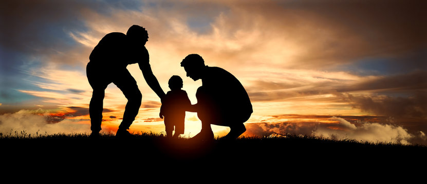 Gay couple with child at sunset. Happy concept of parenting and taking care of children.